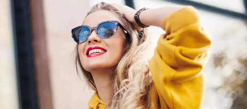 Lingual braces Wimbledon - A woman enjoys a sunny day outdoors, showcasing a confident smile thanks to her lingual braces treatment at Ridgway Dental, a dental clinic in Wimbledon. The clinic specializes in providing discreet orthodontic solutions like lingual braces, which are hidden behind the teeth, offering an invisible way to achieve straight teeth. This image reflects the successful results of modern orthodontic care, emphasizing the clinic's commitment to helping patients in Wimbledon achieve beautiful smiles while maintaining a natural appearance during treatment.